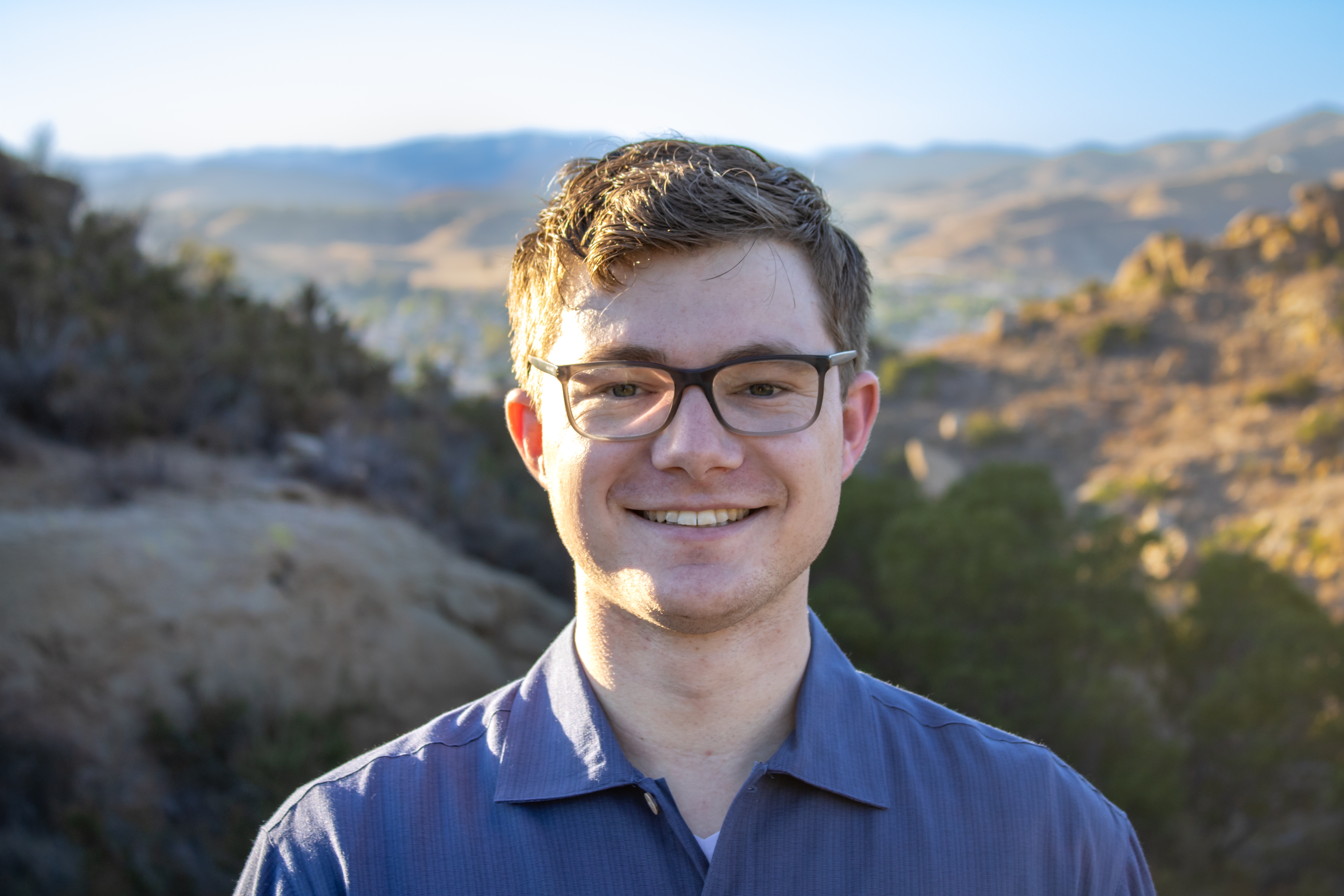 Professional headshot in front of a mountain.