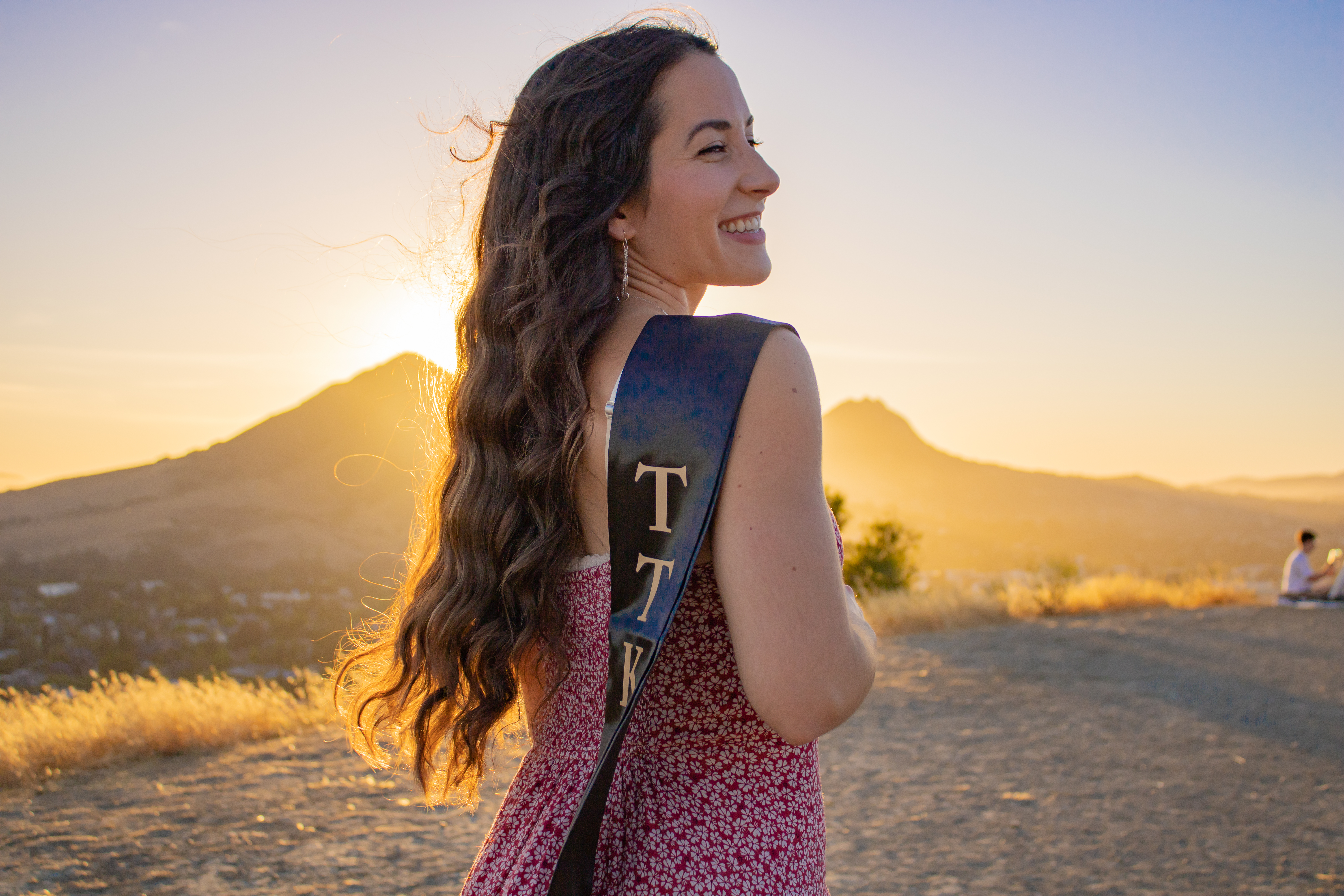 Senior posing in front of sunset.